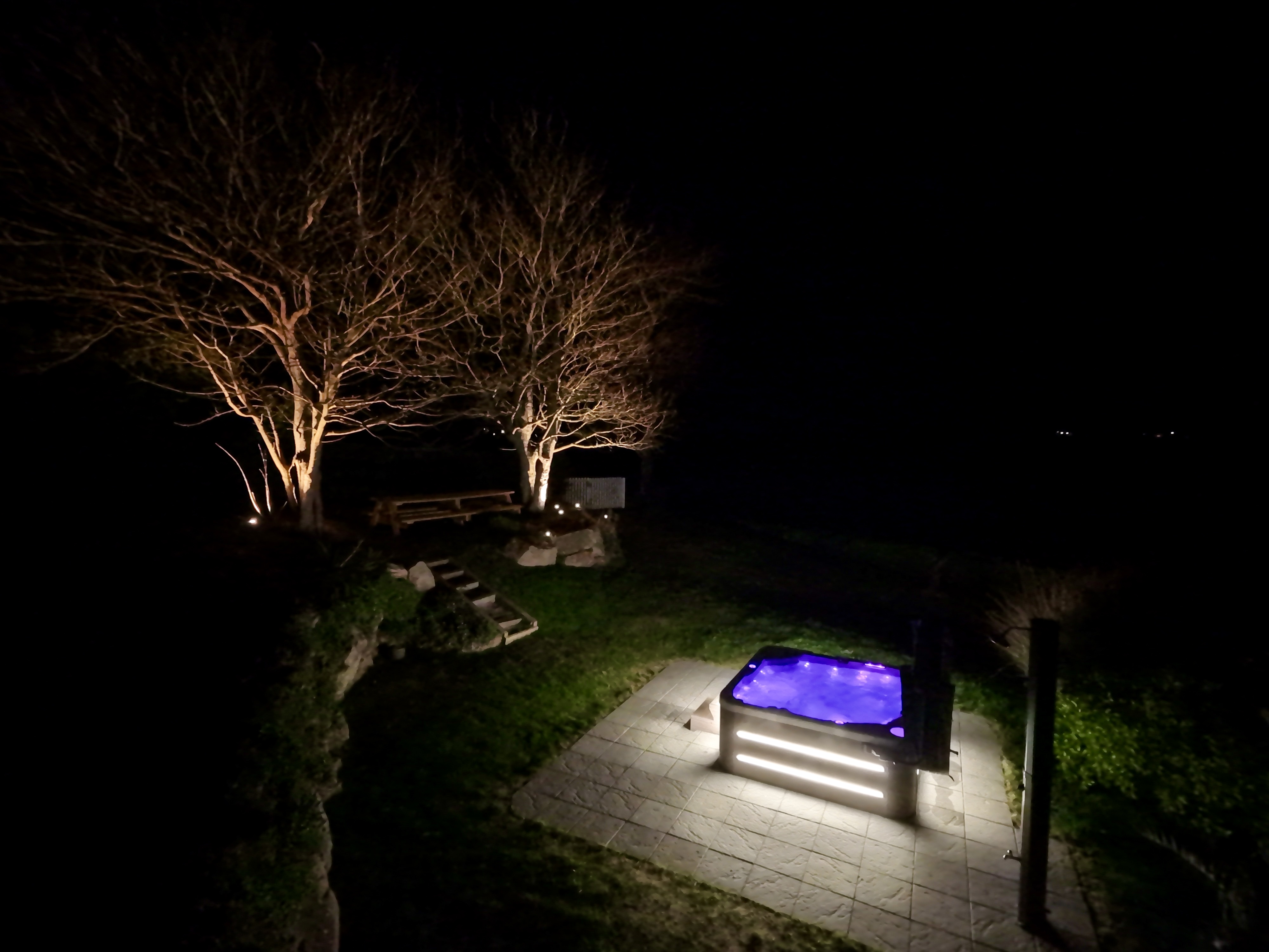 Jacuzzi illuminé de nuit face à l'océan